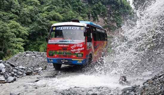 Passenger bus crossing  landslide area in Myagdi
